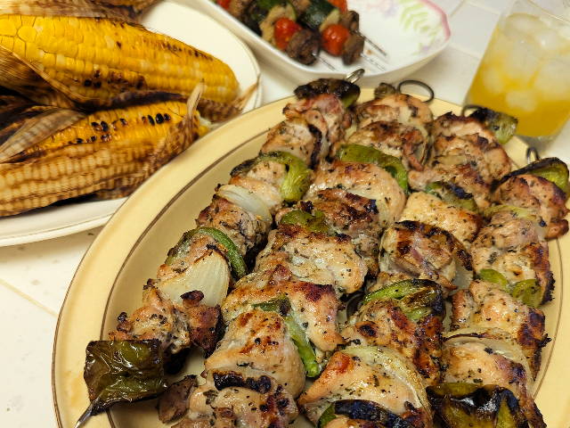 grilled chicken skewers, vegetables, and corn