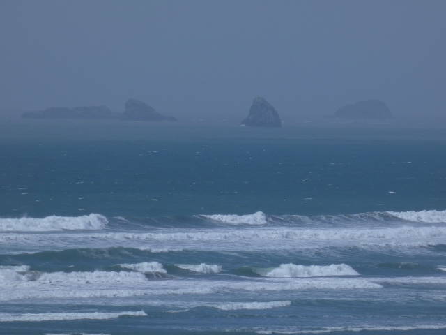 ocean waves crashing wit distant rocks in background