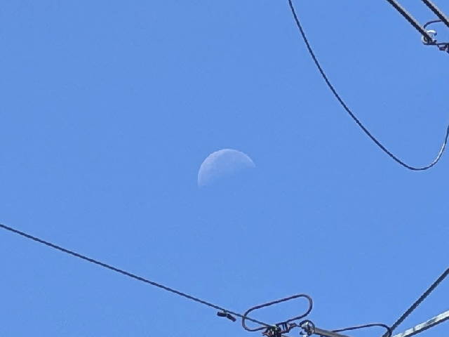 the moon scene in daylight between suspended power cables