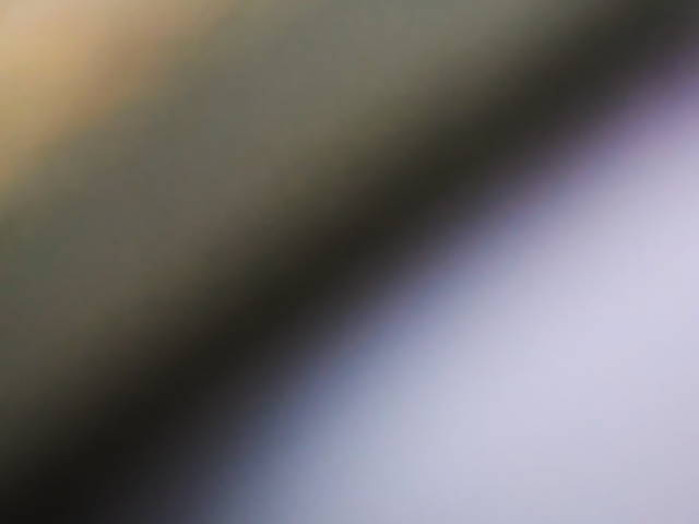 abstract blurred photo depicting tan, black, and light blue gradients
