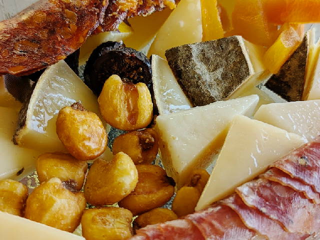 close on a tray of cheeses, dried fruits, and charcuterie