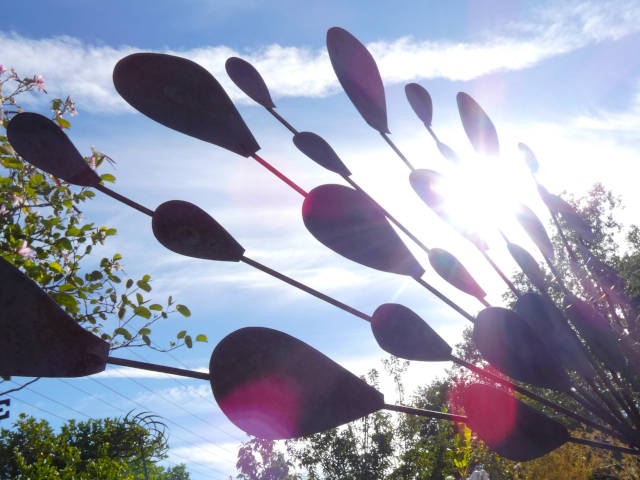 abstract photo of a lawn ornament with sunlight lens flare and blue skies behind