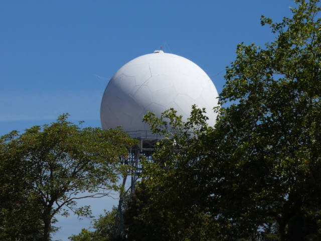 old radar tower partly hidden by trees
