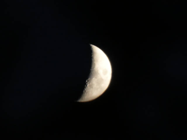the waxing crescent moon shining in the darkness
