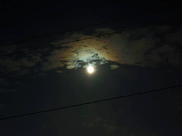 very moody moon lighting up clouds with a halo
