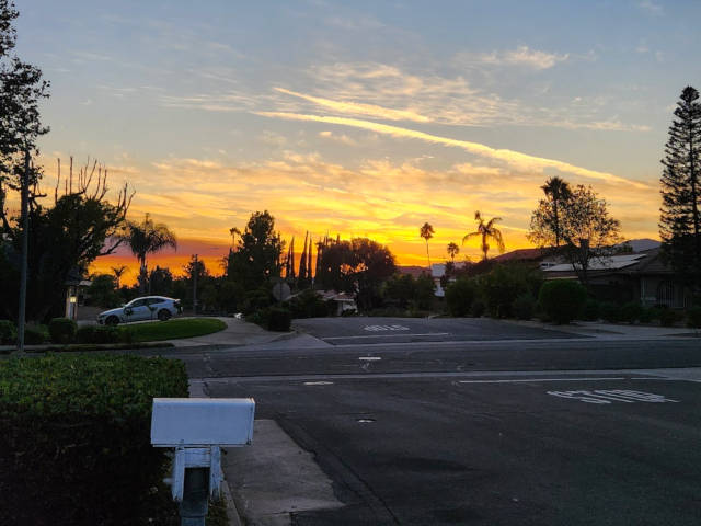sunset with possible smoke plume from distant wildfire low on the horizon
