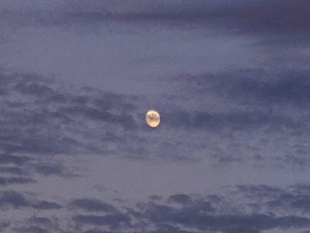our old friend the moon, partly obscured by some dark spotty clouds