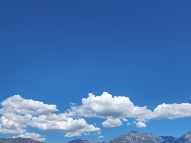 big floofy clouds over the mountain