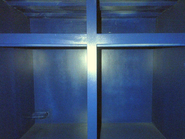 inside the frame of a blue cabinetry with the drawers removed