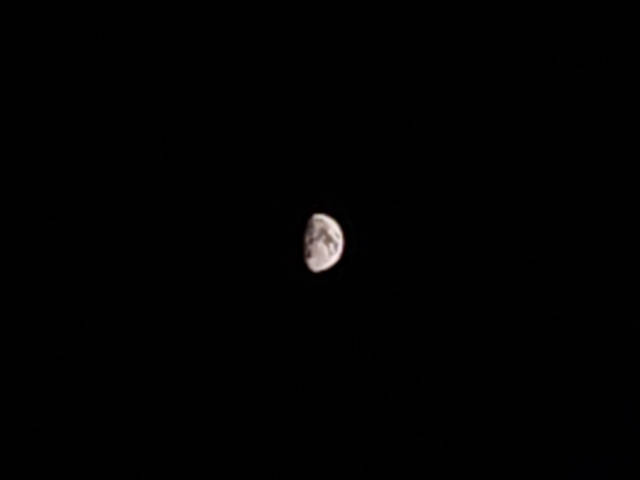 a rather blurry photo of the waxing gibbous moon, small in the frame