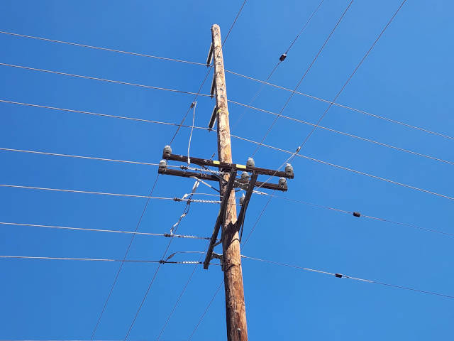 crossing power lines intersection against the bright blue sky
